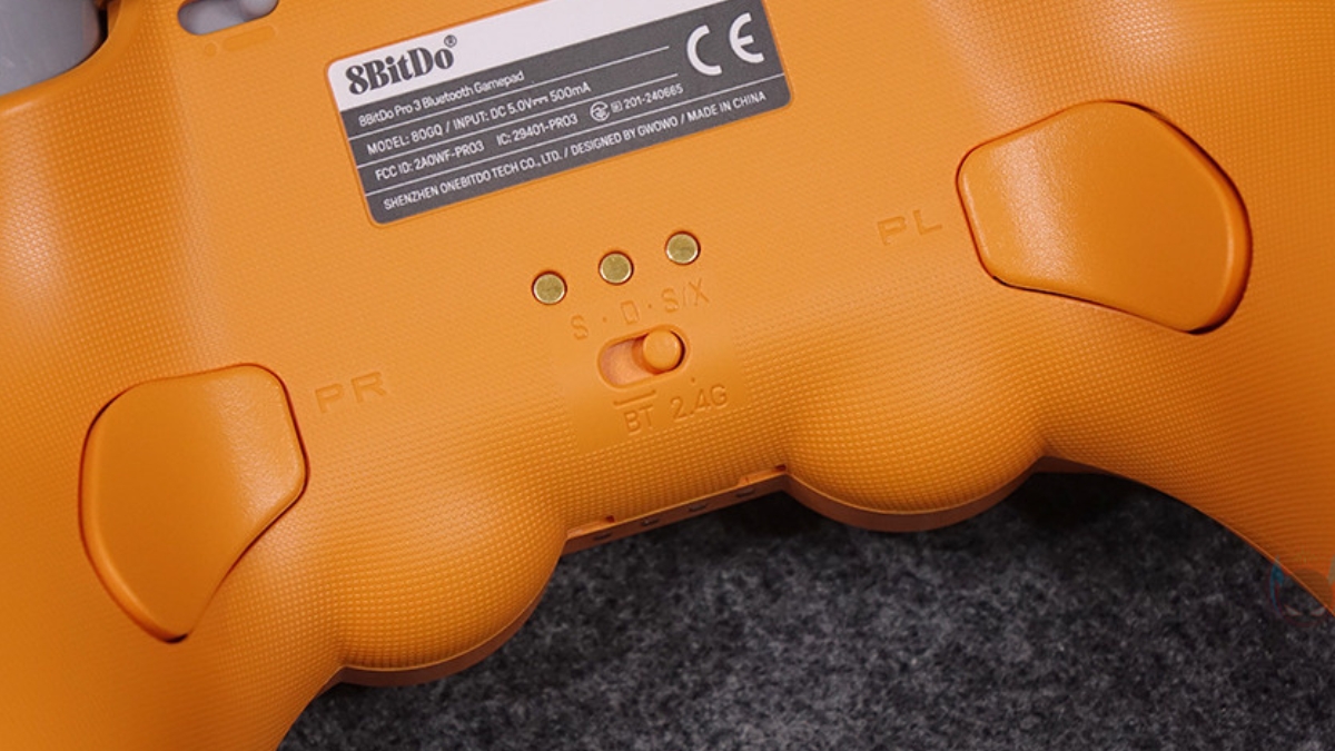 Trên tay 8BitDo Pro 3, mặt trước với D-Pad, XYAB, các nút Start, Home, Profile, LED Indicator, triggers và paddle buttons.