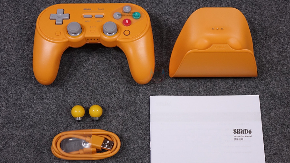 rên tay 8BitDo Pro 3 với dock sạc, tay cầm và phụ kiện được bố trí trong hộp.