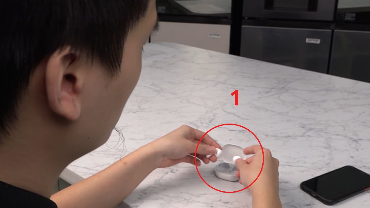 Lấy tai nghe ra khỏi hộp sạc