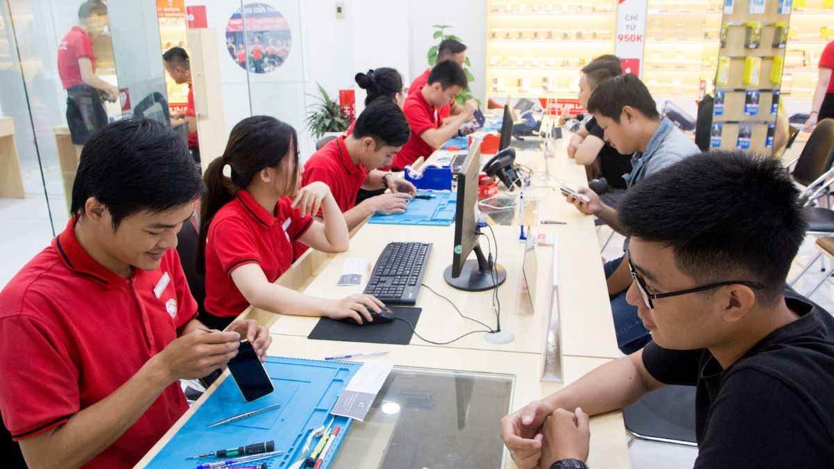 Kỹ thuật viên kiểm tra lỗi điện thoại không nhận sạc chuyên nghiệp tại trung tâm Điện Thoại Vui.