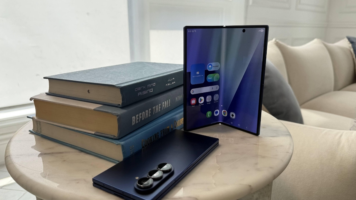 Điện thoại samsung mắc nhất Galaxy Z Fold7 5G đang mở gập đặt trên bàn cạnh sách