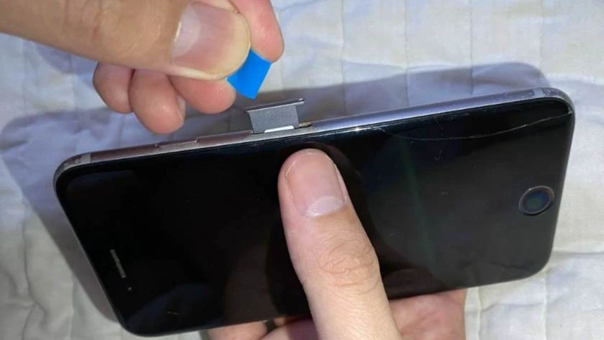 Chèn mảnh nhựa mỏng vào khe cắm sim để thực hiện cách tháo khay sim khi bị kẹt