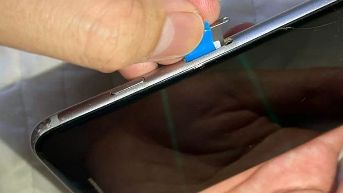 Tiếp tục đẩy miếng nhựa mỏng sâu vào khe cắm sim để lấy khay sim ra