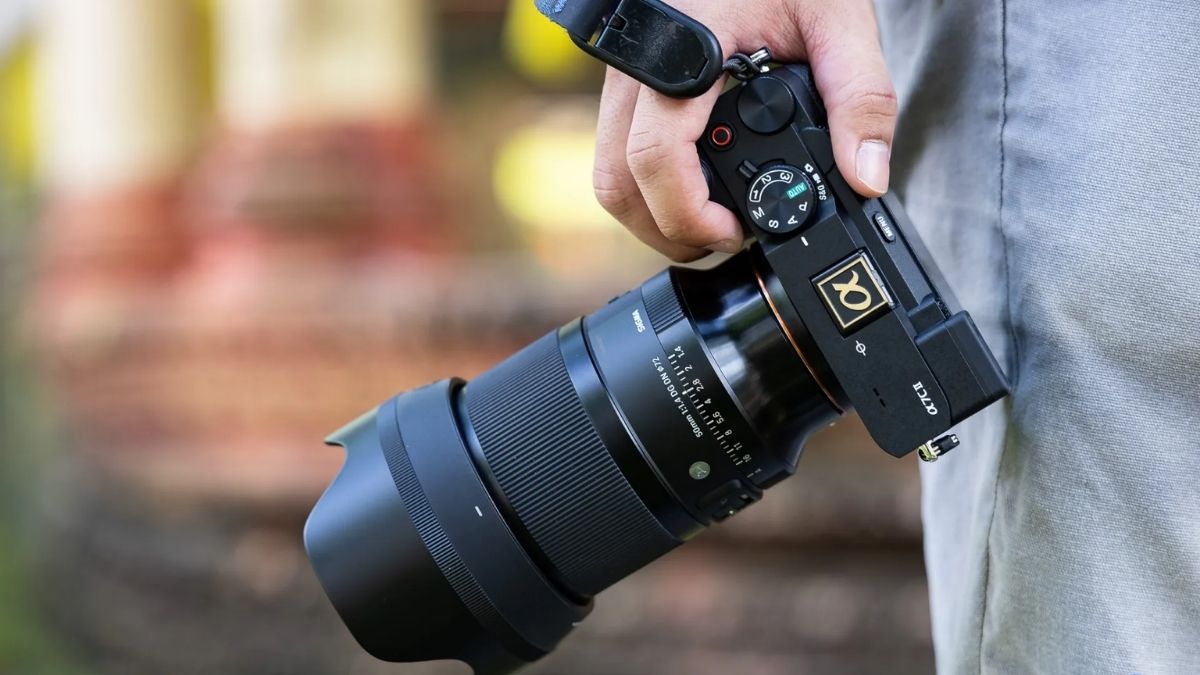 Người dùng cầm máy ảnh chuyên nghiệp tìm hiểu EV trong máy ảnh là gì để phơi sáng.