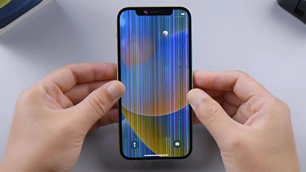 Hai tay đang giữ iPhone 15 Pro Max với màn hình bị lỗi sọc và màu sắc bất thường, minh họa dấu hiệu cần chẩn đoán.
