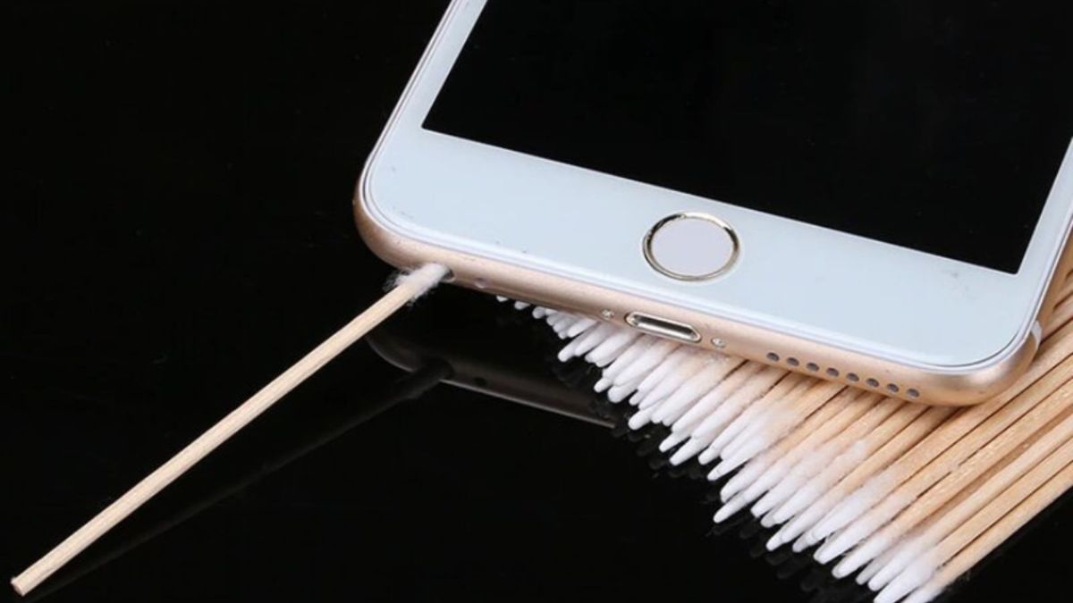 Thao tác sử dụng tăm bông vệ sinh cổng sạc và mic thoại, giải pháp khắc phục lỗi mic iPhone do bụi bẩn.