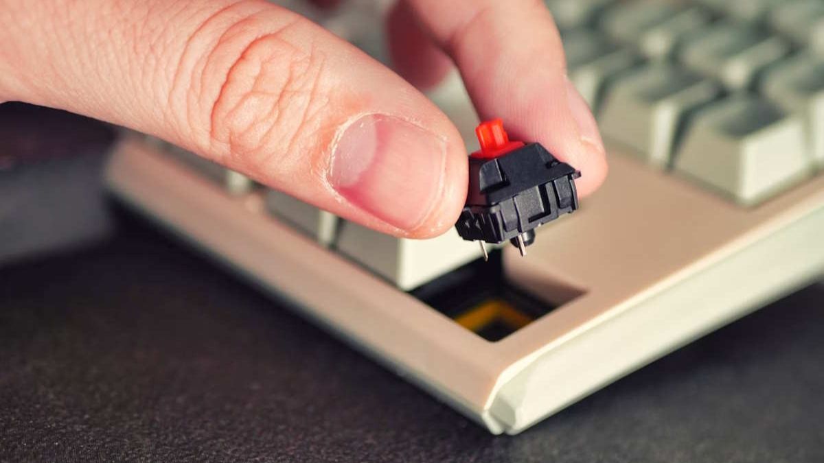 Cận cảnh tay tháo switch khi chuẩn bị thay keycap cho bàn phím cơ tại nhà.