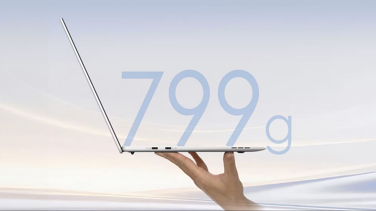 Một bàn tay cầm thanh lịch một chiếc laptop mỏng màu bạc với văn bản 799g được phủ lên, làm nổi bật thiết kế nhẹ nhàng của nó
