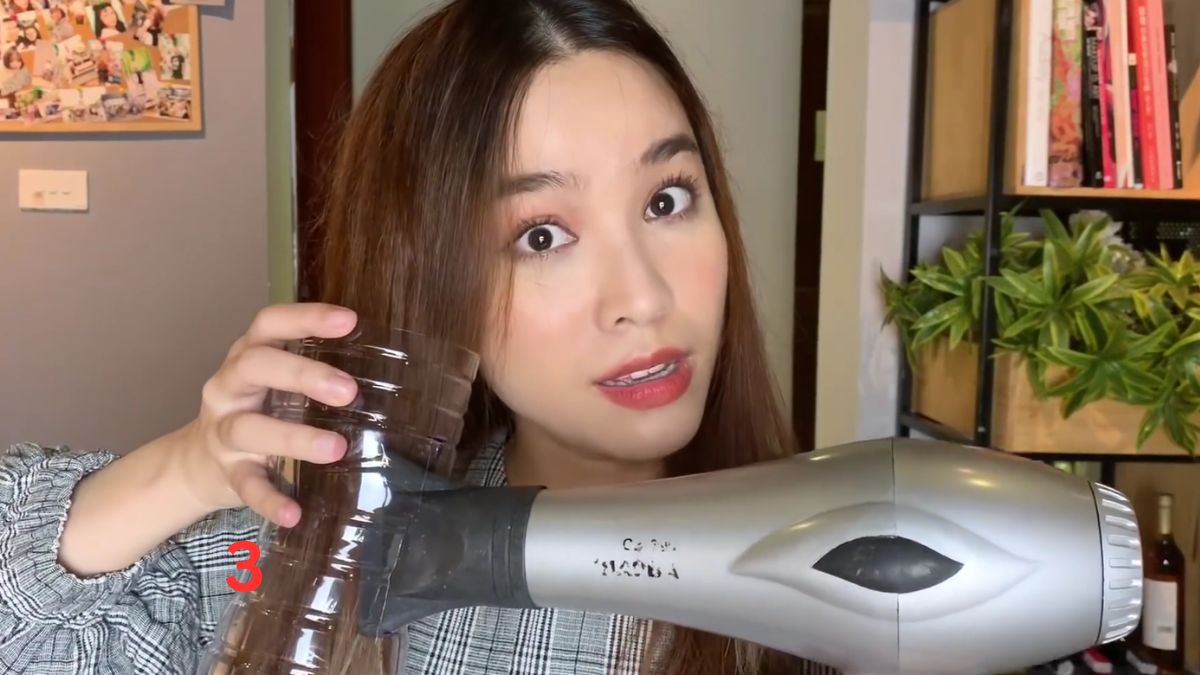 Hướng đầu máy sấy vào lỗ bên hông chai