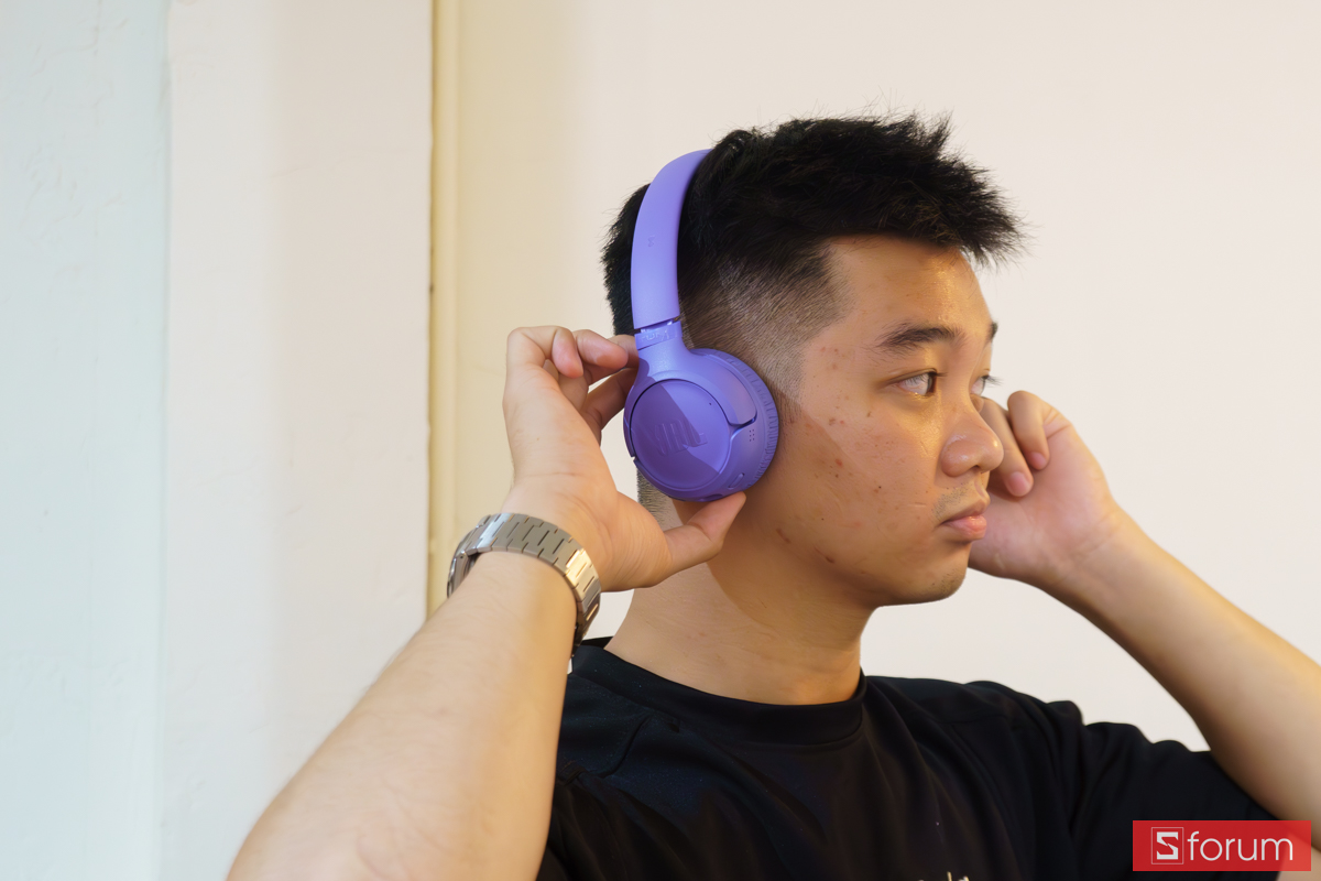 Người dùng thao tác điều chỉnh tai nghe JBL Tune 530BT khi đeo trên tai