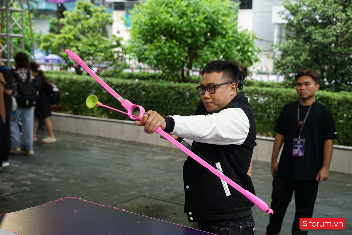 Hoàng Luân tham gia booth game bắn cung